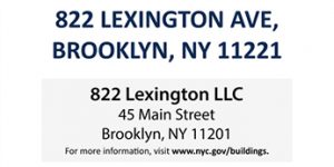 White sidewalk shed sign with contractor logo, company name, and project site address for NYC construction site compliance.
